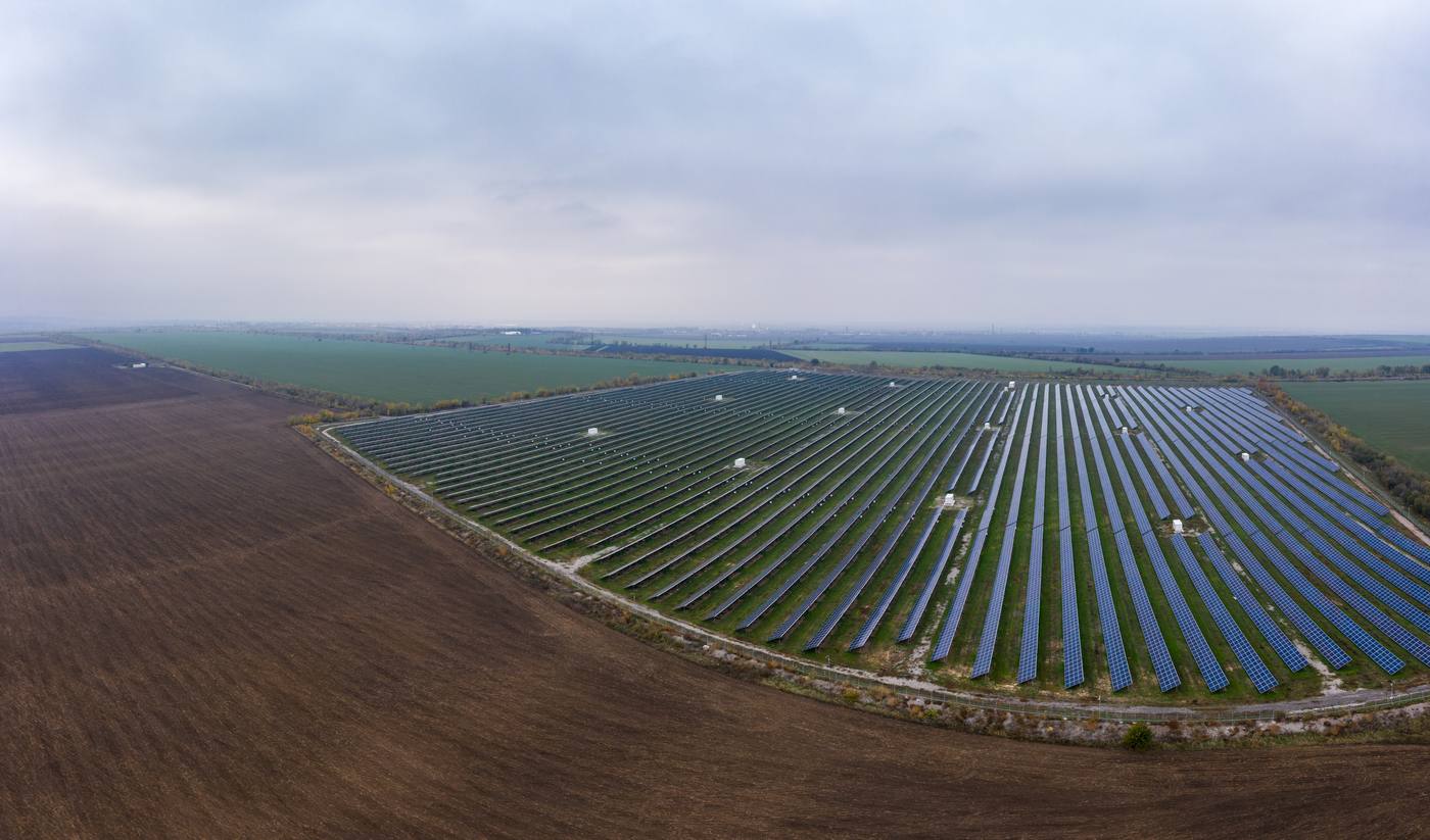 Aerial view of a large solar farm under an overcast sky